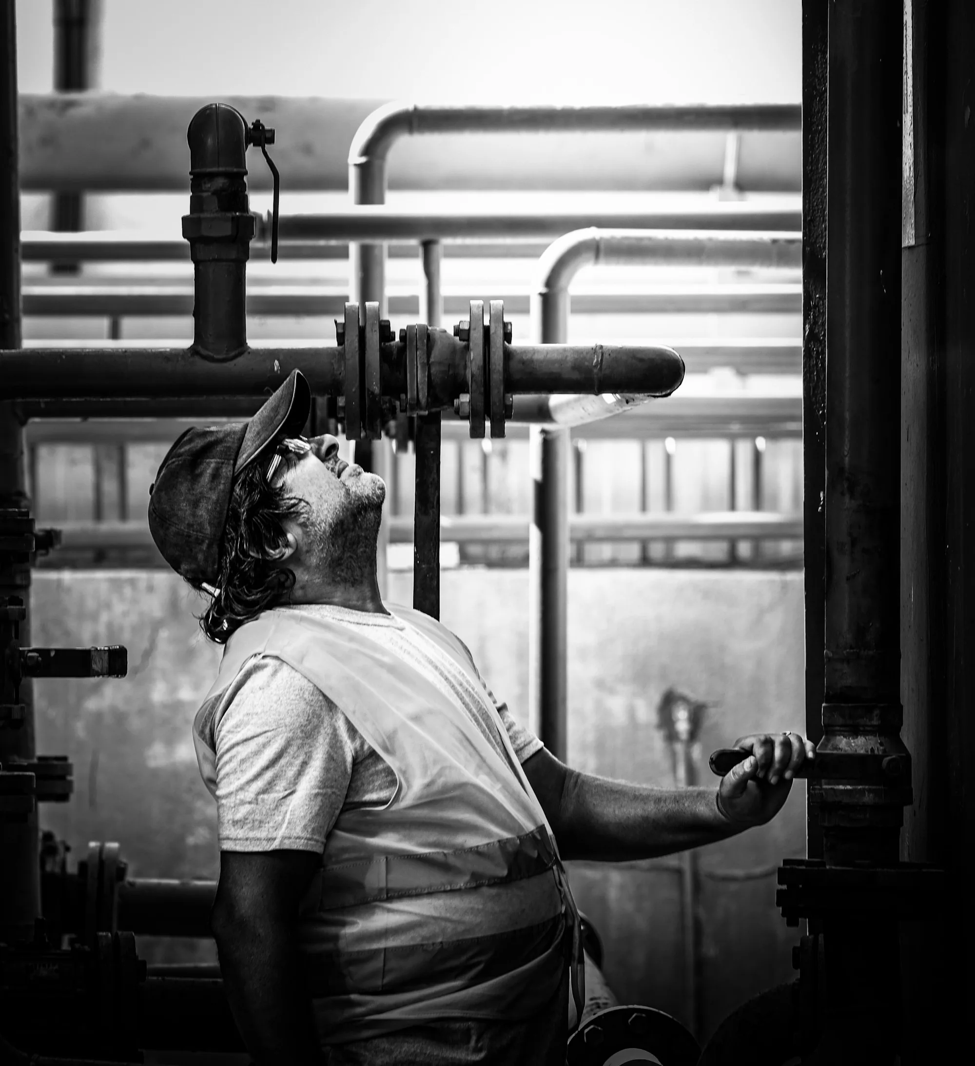 Technician inspecting industrial pipes and valves